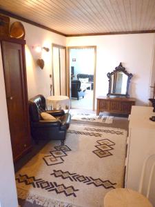 sala de estar con silla de cuero negro y alfombra en Apartments Green Paradise, en Bohinjska Bela