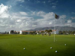 a golf course with a flag and balls on a green at Parador de Málaga Golf in Málaga