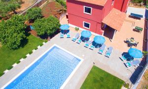 una vista aérea de una piscina con sillas y una casa en Villa Zanzibar by Algarve Vacation, en Olhos de Água
