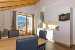 a kitchen with a table and a view of a mountain at Latemar Fiemme Apartments in Tesero
