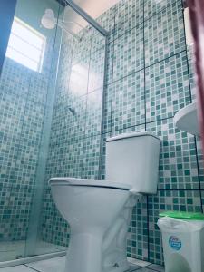 a bathroom with a toilet and a glass shower at Hotel Maracá in Boa Vista