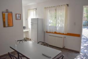 a kitchen with a table and a white refrigerator at Ruca Hue in Puerto Madryn