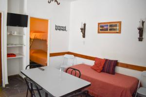 Cette chambre comprend une table, un lit, une table et des chaises. dans l'établissement Ruca Hue, à Puerto Madryn