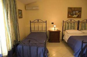 1 dormitorio con 2 camas, mesa y ventana en Tavernola - Locanda Di Campagna, en Battipaglia