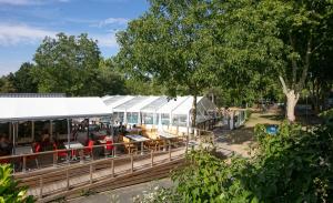 a train station with tables and chairs in a park at Camping La Belle Etoile in Melun