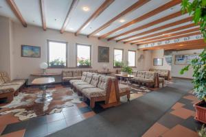 a waiting room with couches and tables and windows at TOP Appartamenti in Passo del Tonale