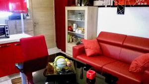 a living room with a red couch and a table at Apartment - Sleeps 3 & swimming pool in Realmonte