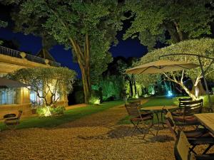a table and chairs with an umbrella at night at Château Rieutort Gîtes in Saint-Pargoire