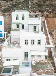 una casa blanca con escaleras que conducen a ella en Theasis Suites, en Amorgós