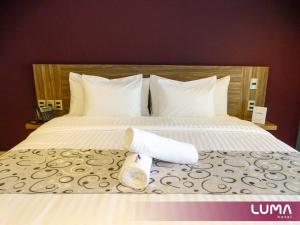- un lit avec 2 rouleaux de serviettes dans l'établissement Hotel Luma by Kavia, à Cancún