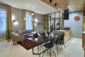 une salle à manger et une cuisine avec une table et des chaises en verre dans l'établissement ORANGEHOMES Unique design 3 bathrooms flat, à Budapest