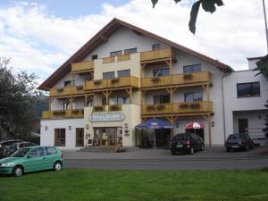 a large building with cars parked in front of it at Rhöner Landhotel Haus zur Wasserkuppe in Ehrenberg