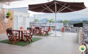 弗洛伦西亚Hotel Caquetá Real HSC的带桌椅和遮阳伞的露台