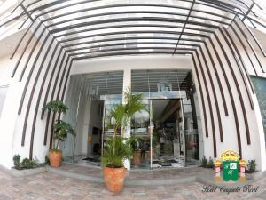 a glass building with palm trees in front of it at Hotel Caquetá Real HSC in Florencia