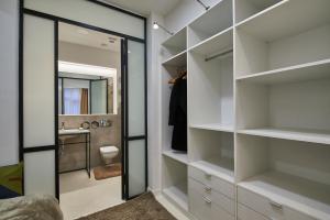 Elle comprend un dressing avec des étagères blanches et un miroir. dans l'établissement ORANGEHOMES Unique design 3 bathrooms flat, à Budapest