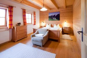 um quarto com uma cama e uma cadeira em um cômodo em Chaletwohnung Lederer em Ebbs