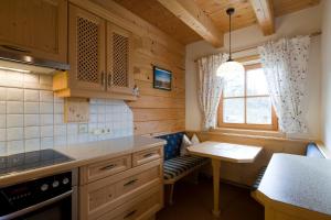 eine kleine Küche mit einem Tisch und einer Bank in der Unterkunft Chaletwohnung Lederer in Ebbs