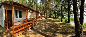 拉伊格鲁德Łabędź I Domki nad jeziorem的树林中的小屋,带围墙门廊 更多29张照片