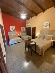 a bedroom with two beds and a couch and a table at Portal los Castaños in Tegucigalpa