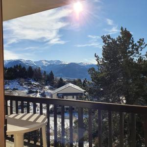 uma varanda com uma mesa e vista para as montanhas em Charmant studio face aux Pyrénées em Font Romeu Odeillo Via