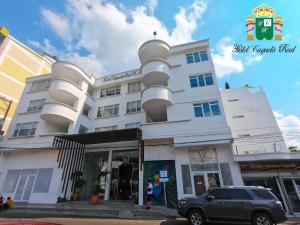 a white building with a car parked in front of it at Hotel Caquetá Real HSC in Florencia