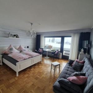 a living room with a bed and a couch at Bergkristall - Freie Fahrt Allgäuer Hörnerbahnen im Sommer in Bolsterlang