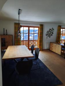 sala de estar con mesa de madera y sillas en Ferienwohnung Hahnenkammblick en Kitzbühel