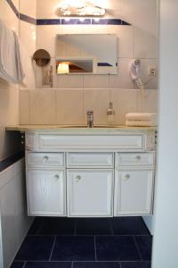 W łazience znajduje się biała umywalka i lustro. w obiekcie Gästehaus Elzblick w mieście Rust