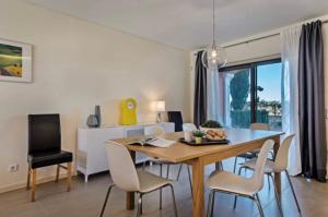 een eetkamer en een woonkamer met een tafel en stoelen bij Villa Lux - 5O in Luz de Tavira