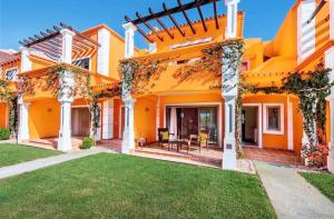 een oranje huis met een gazon ervoor bij Villa Lux - 5O in Luz de Tavira