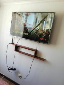 TV de pantalla plana colgada en la pared en Departamento amoblado, en Talca