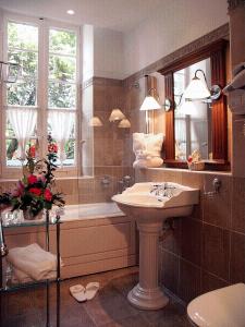 y baño con lavabo y bañera. en Château des Comtes de Challes en Challes-les-Eaux