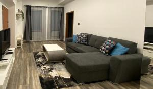 a living room with a couch and a tv at Hősök Tornya Apartman in Kőszeg