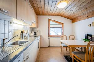 a kitchen with a sink and a table at Haus Derby in Samnaun