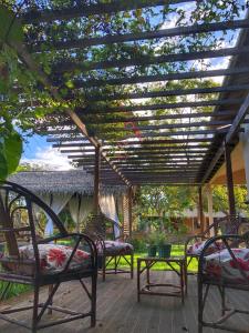 a group of chairs sitting under a pergola at Casa de Férias em Alter do Chão-PA in Alter do Chao