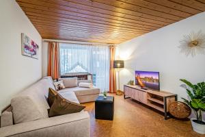 ein Wohnzimmer mit einem Sofa und einem Flachbild-TV in der Unterkunft Haus Derby in Samnaun