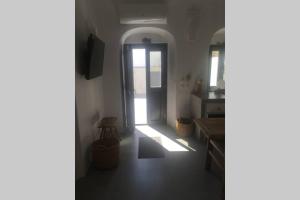 a hallway with a door leading to a kitchen at Santorini Folia Cave house, 4 pers, view, jacuzzi in Pirgos