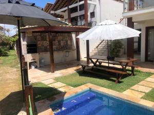 - une terrasse avec une table et un parasol à côté de la piscine dans l'établissement Casa Taíba Beach Resort, à Taíba