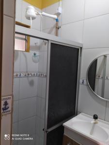 a bathroom with a shower with a sink and a mirror at Pousada Belo Mar in Maceió