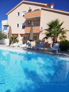 a large swimming pool in front of a building at Apartments Zeneral in Novalja