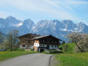 a house on the side of a road with mountains at Ferienwohnung Hahnenkammblick in Kitzbühel