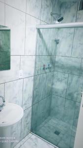 a bathroom with a shower and a sink at Hotel Atlântico in Americana