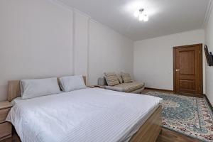 a white bedroom with a bed and a couch at BI CITY SEUOL 116 in Astana