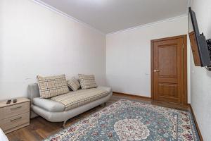 a living room with a couch and a tv at BI CITY SEUOL 116 in Astana