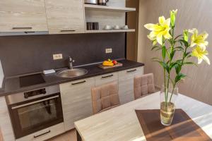 a kitchen with a table and a vase with yellow flowers at Luxury Apartments Queen in Petrovac na Moru