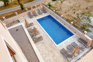uma vista sobre uma piscina com cadeiras e uma piscina em Luxury Apartments Queen em Petrovac na Moru