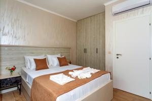 a bedroom with a bed with towels on it at Luxury Apartments Queen in Petrovac na Moru