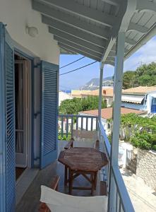 a table and chairs on a porch with a table at Elena Rooms in Agios Nikitas