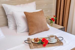 a tray of food and a cup of coffee on a bed at Luxury Apartments Queen in Petrovac na Moru