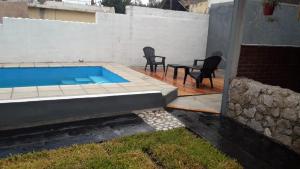 a swimming pool with two chairs and a table and a table and chairs at Doña Aida in Mina Clavero